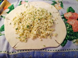 Put the filling in the center of the flattened dough and cut the circle into 5 pieces.